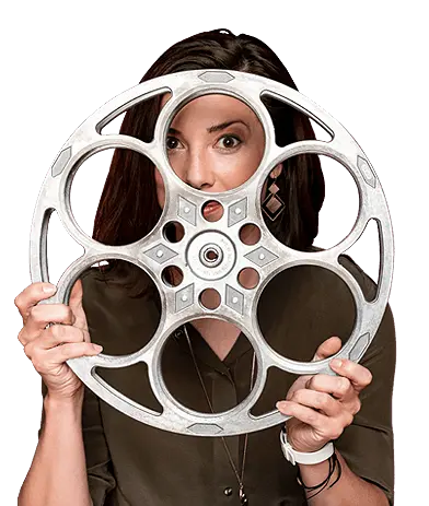 Media A woman holding up a silver film reel.
