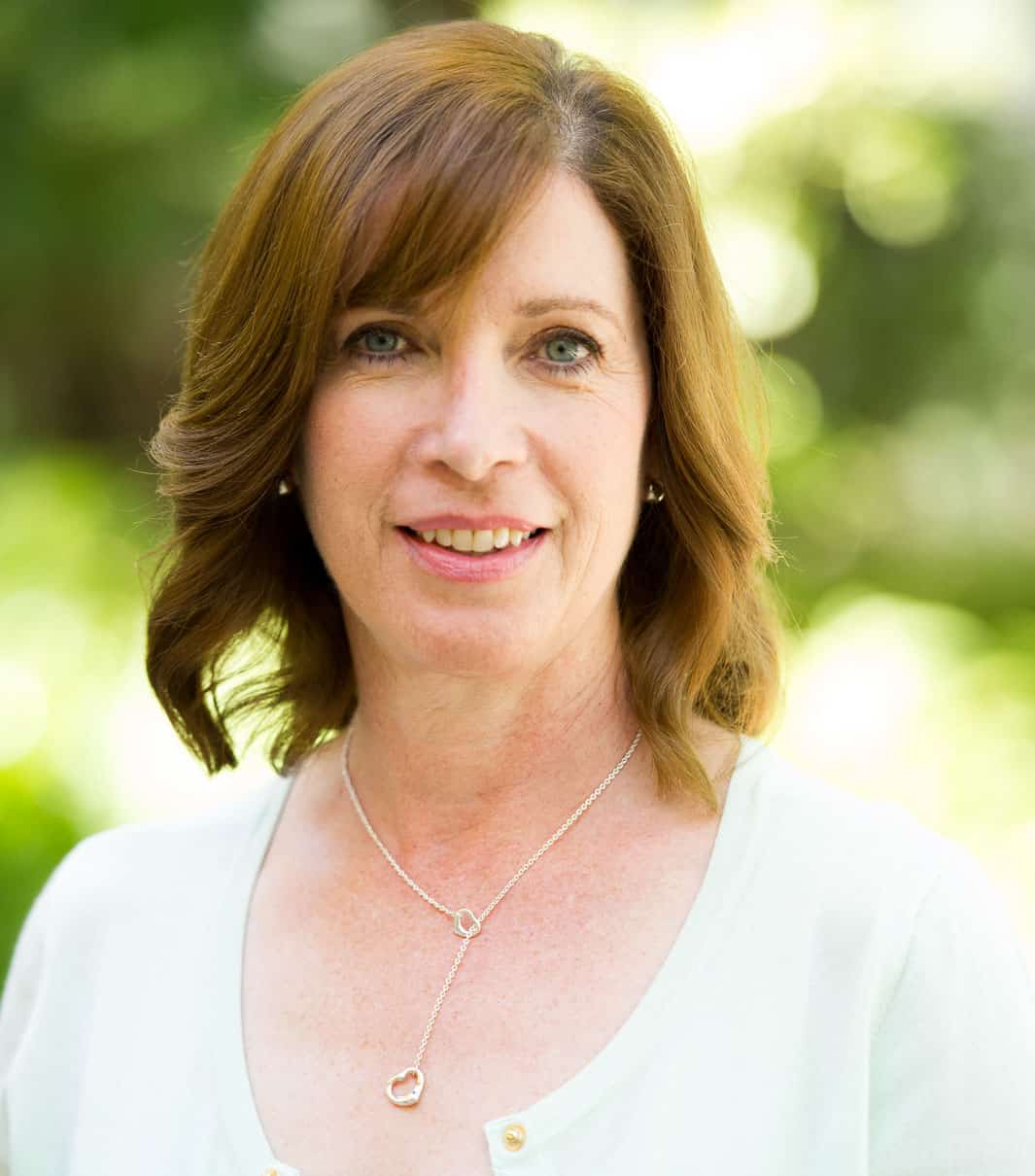 rachel reiff A woman wearing a white shirt and a necklace.