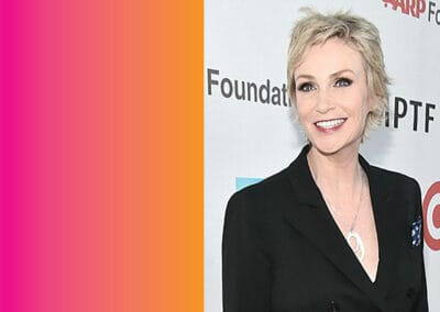 JaneLynch A woman in a black suit is posing for a photo.