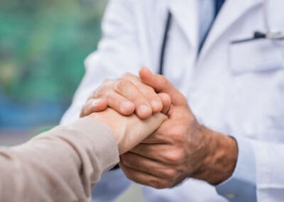 Patient care A doctor shaking hands with a patient.