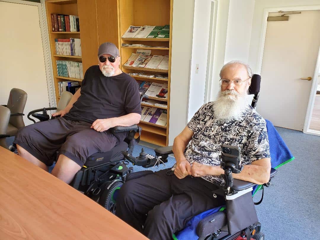 D&S 1 Two men in wheelchairs sitting at a table.