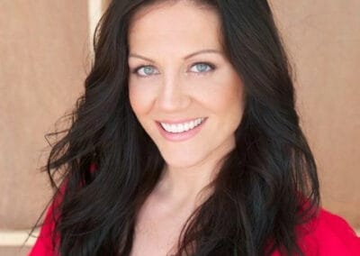 Melissa Ritz A woman with long black hair smiling in a red shirt.