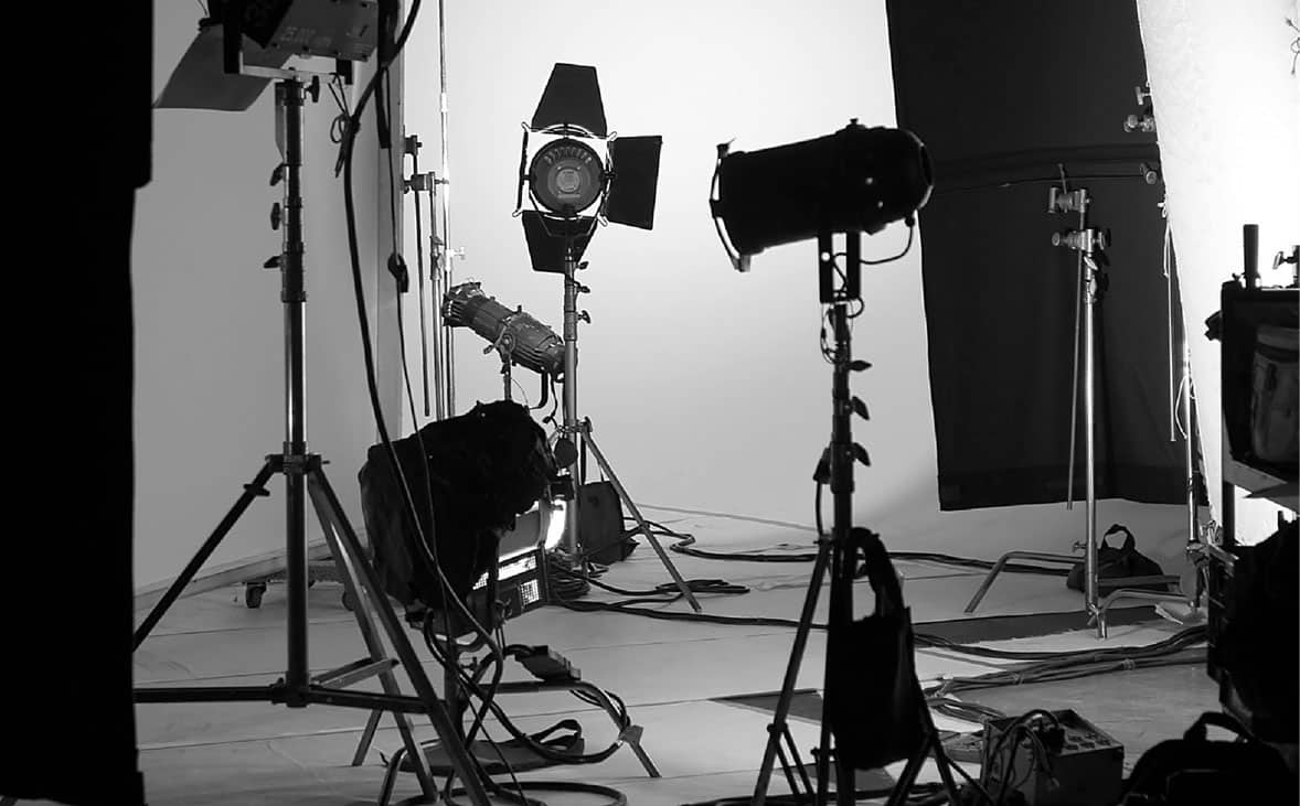 Production Set A black and white photo of a studio with lighting equipment.